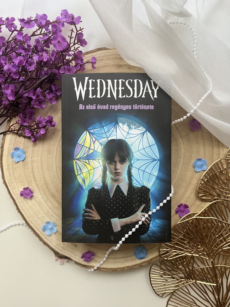 Tehlor Kay Mejla: Wednesday - Az első évad regényes története 
„Sötét humor, morbid báj és egy lány, aki sosem mosolyog.”
A Wednesday története pontosan olyan, mint a főhőse: különc, éles eszű és eg